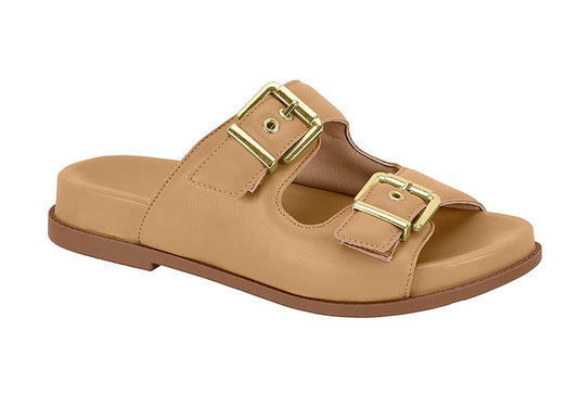 Product shot of a beige leather slide sandal with two gold buckles and a brown sole showing off its comfortable design and stylish features