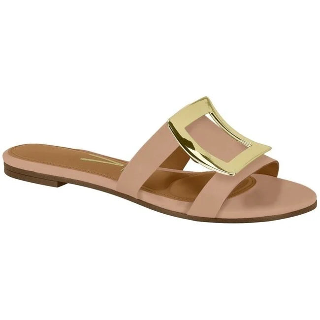 Product shot of a blush-pink women's slide sandal featuring a large gold buckle a subtle tan insole and a sleek minimalist design