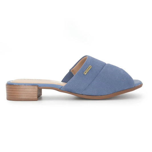 Modare product shot showcasing a dusty blue denim women's mule with a low wooden block heel and a gold logo detail
