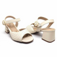 Product shot of a pair of cream-colored Vizzano sandals featuring a unique quilted design,  a gold buckle accent, and a chunky block heel against a white background
