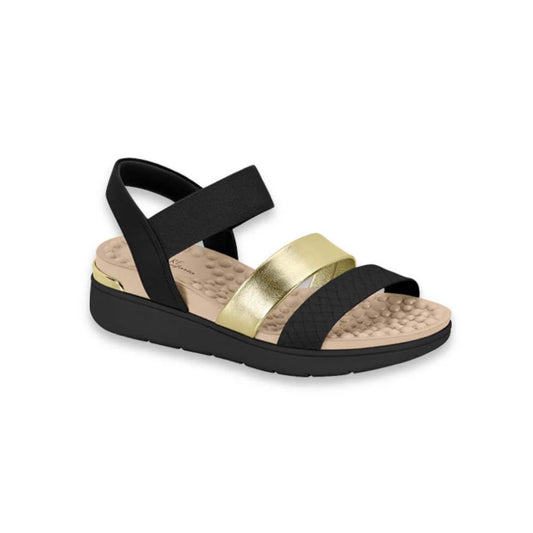Product shot of a black and gold REEF sandals featuring a textured footbed and a black elastic strap.
