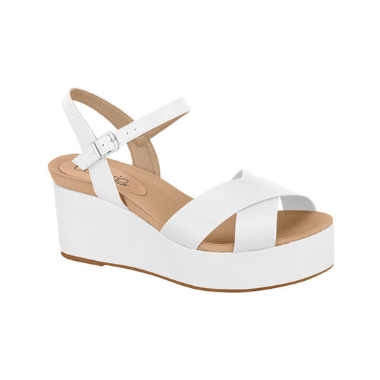 Product shot of a white leather Celio platform wedge sandal featuring a crisscross strap design a beige insole and a silver buckle
