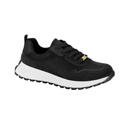Product shot of a black sneaker with white sole and gold accent featuring a textured upper and chunky outsole
