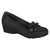 Product shot of a black wedge loafer with gold accents and a subtle bow detail showcasing a textured upper and a slightly chunky sole
