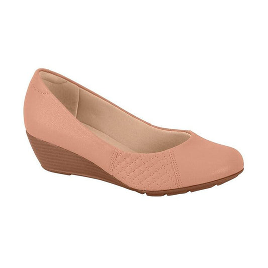 Product shot of a blush-pink wedge shoe featuring a quilted detail a beige insole and a brown wedge heel
