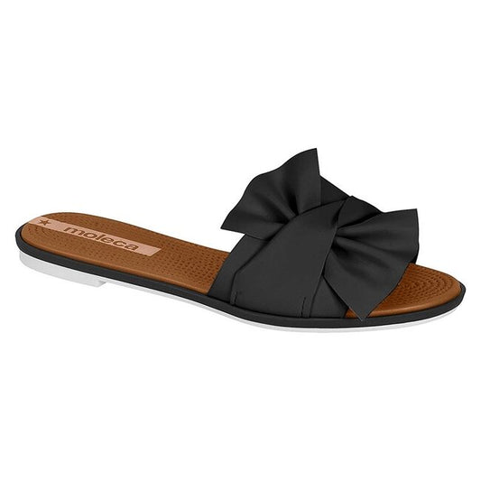 Moleca black slide sandal featuring a large fabric bow a brown footbed and a white sole
