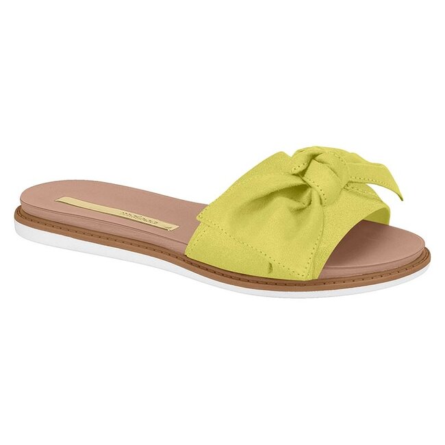 Product shot of a lime green suede slide sandal with a large bow featuring a neutral-toned insole and brown-and-white platform sole
