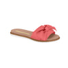 Product shot of a coral-colored Grendha slide sandal featuring a large fabric bow detail a beige insole and a white and brown sole
