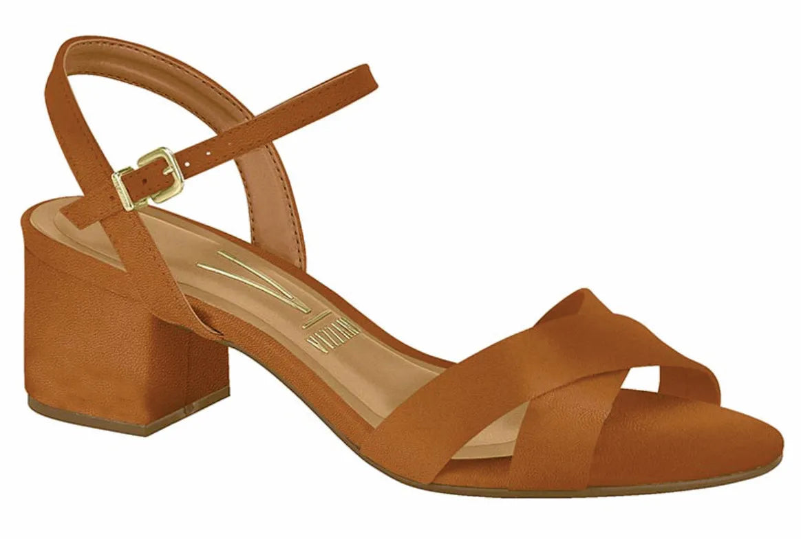 Product shot of a Vizzano brand camel-colored low heeled sandal featuring a gold buckle ankle strap and crisscross toe straps  with a subtle textured finish
