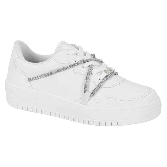 Product shot of a white leather sneaker with silver glitter laces and a chunky sole
